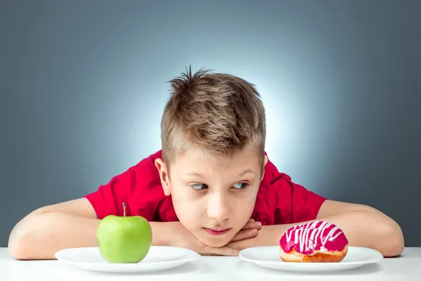 child-boy-chooses-donut-green-apple-concept-resistance-temptation-fast-food-healthy-food-diet.webp דיאטה לילדים