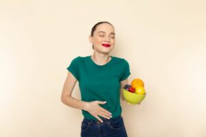 אישה מחזיקה קערה עם פירות