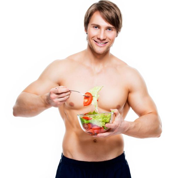 גבר שרירי אוכל סלט ירקות
