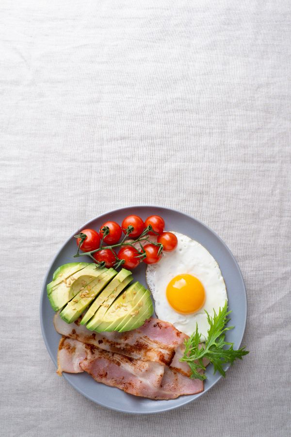 ארוחת בוקר לפי התזונה הקטוגנית הכוללת ביצת עין, עגבניות ואבוקדו